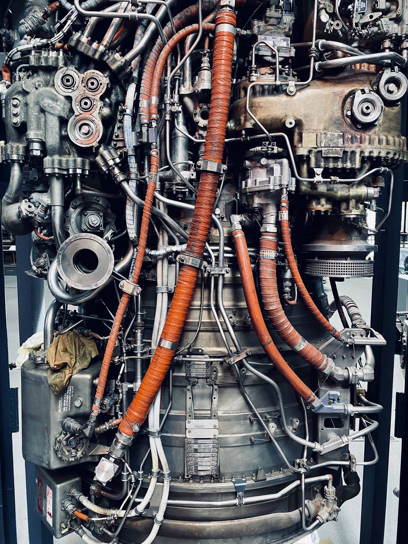 Jet engine accessory section showing pipework, fittings and fire-sleeved hoses