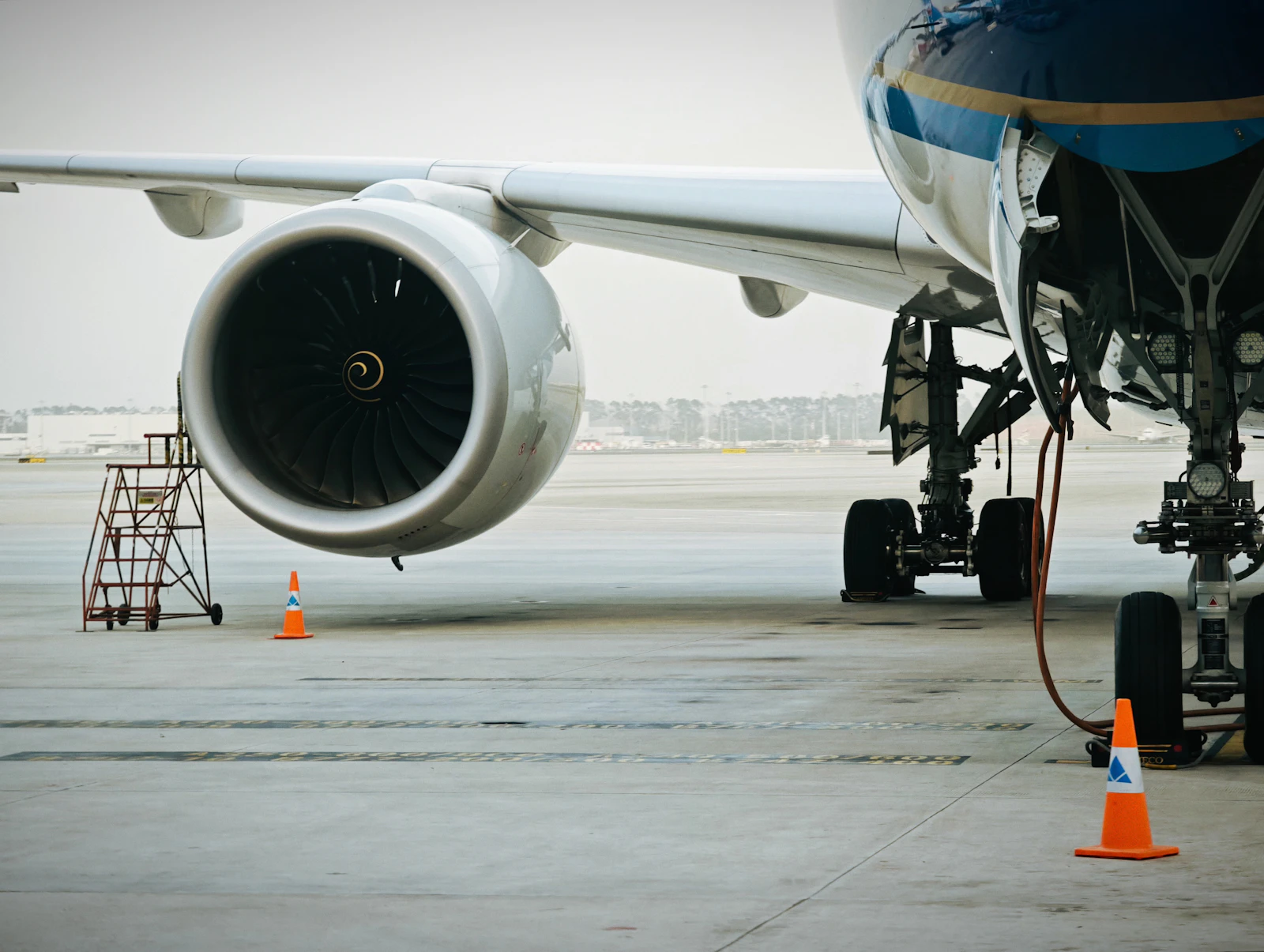 Engine nacelle, wing and main landing gear of a widebody aircraft parked on the apron